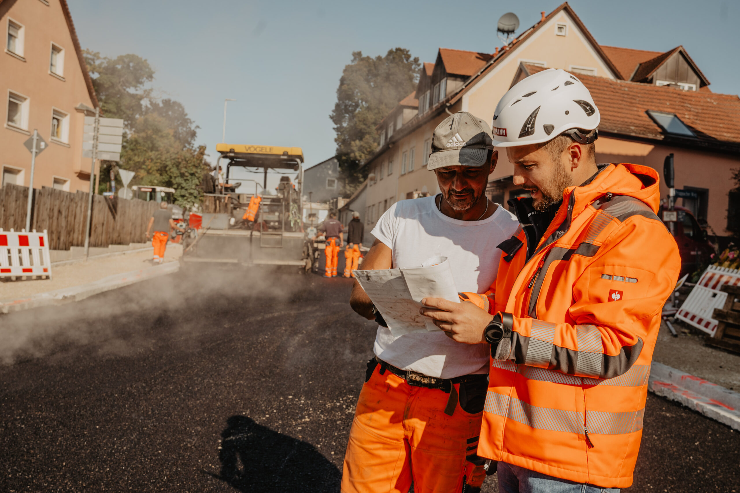 Facharbeiter im Tiefbau auf einer Baustelle Straßenbauarbeiten bei der Hans Hirschmann KG Moderne Baumaschinen im Einsatz Team der Hans Hirschmann KG auf der Baustelle