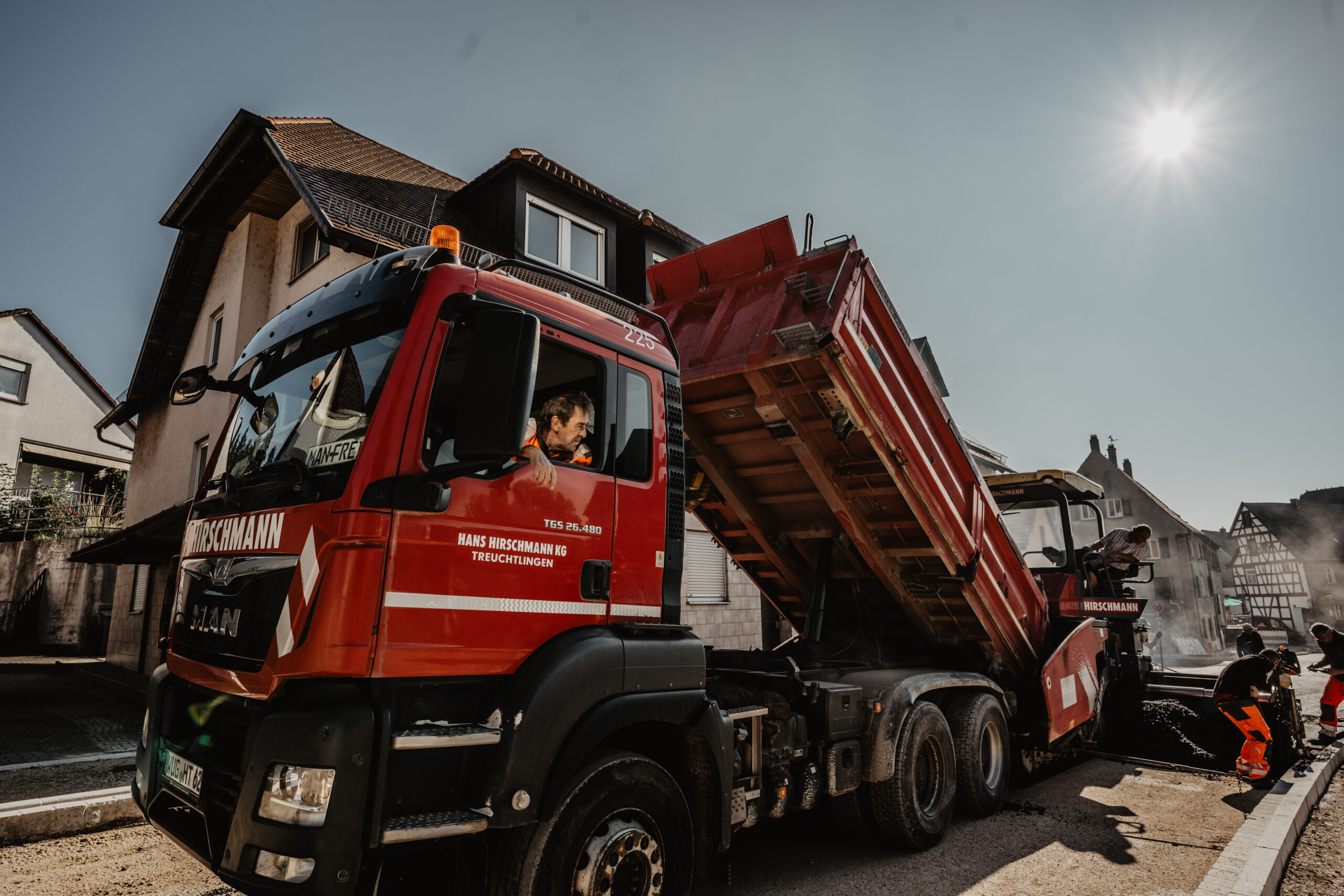 LKW der Hans Hirschmann KG auf einer Baustelle Berufskraftfahrer im Baustellenverkehr Tieflader transportiert Baumaschine Moderner Fuhrpark der Hans Hirschmann KG